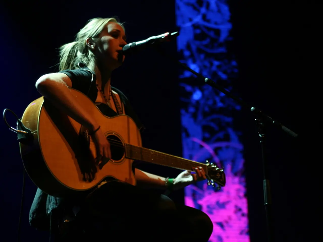 Strumming the acoustic guitar plays the intro of Wonderwall, a tune often associated with the...