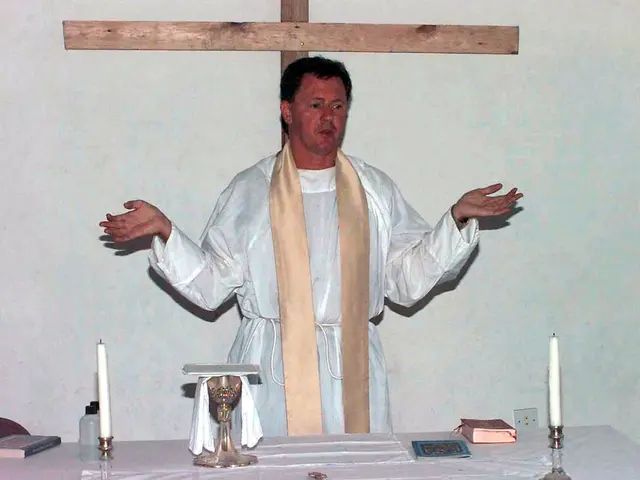 In this picture there is a priest in the center of the image and there is a table in front of him,...
